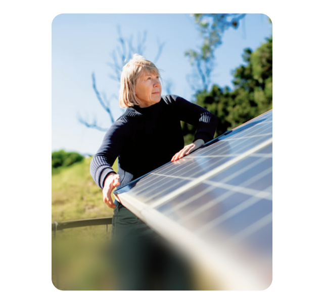 Imagem de uma pessoa a observar um painel solar que transmite um compromisso com a sustentabilidade e transição energética. 